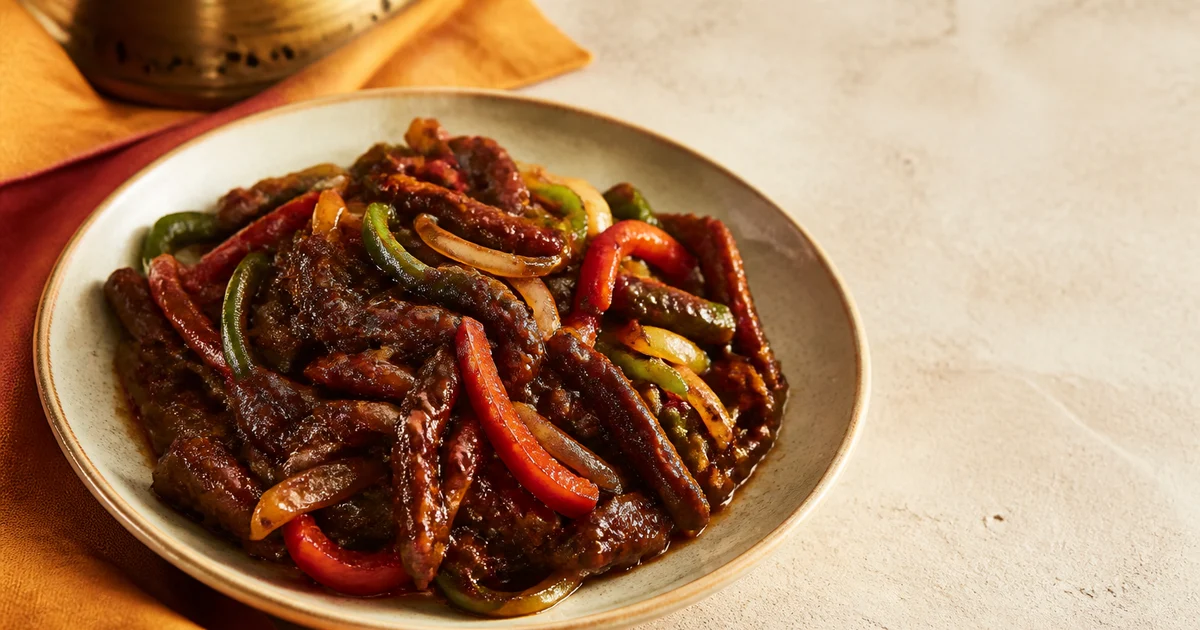 Glossy beef chilli onion with thin beef slices, onion wedges, green capsicum and green chillies served hot from a wok.
