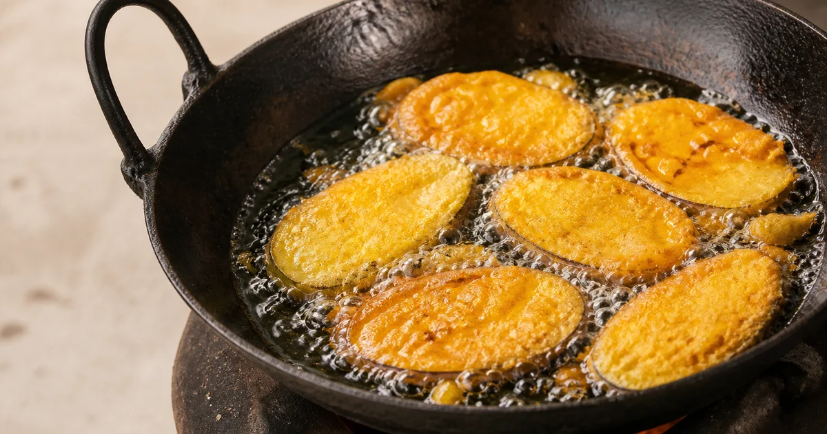 Freshly fried Bangladeshi beguni with crisp golden besan coating arranged on a draining rack.