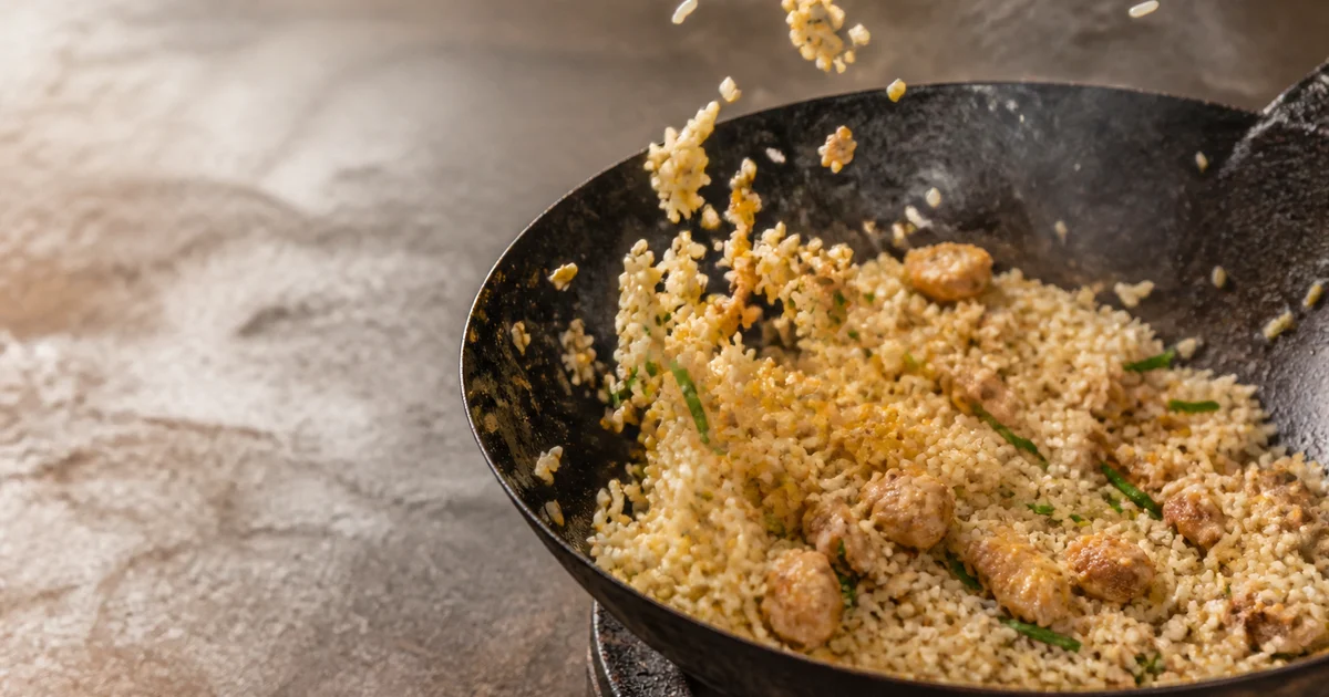 A commercial wok-fried chicken fried rice plate with egg, diced vegetables and spring onion.